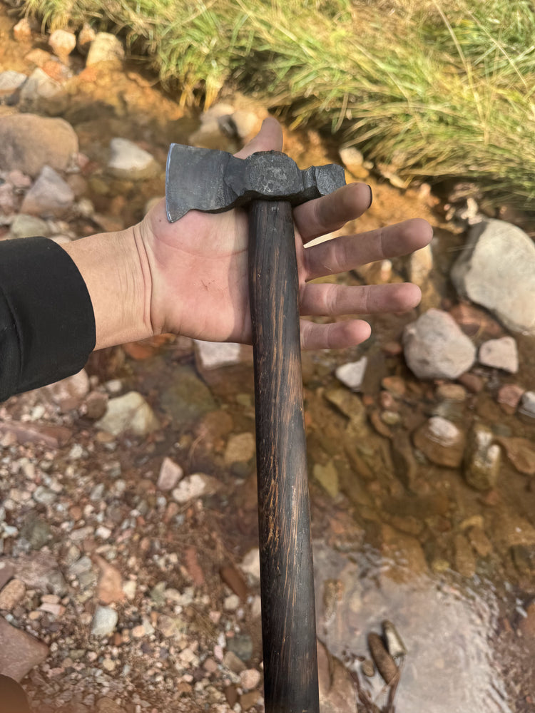 Forged tomahawk with a dark wood handle